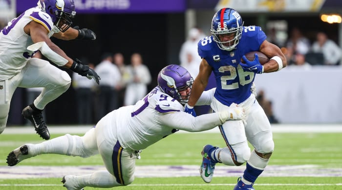 Dec 24, 2022; Minneapolis, Minnesota, USA; New York Giants running back Saquon Barkley (26) is tackled by Minnesota Vikings defensive tackle Harrison Phillips (97) during the fourth quarter at U.S. Bank Stadium.